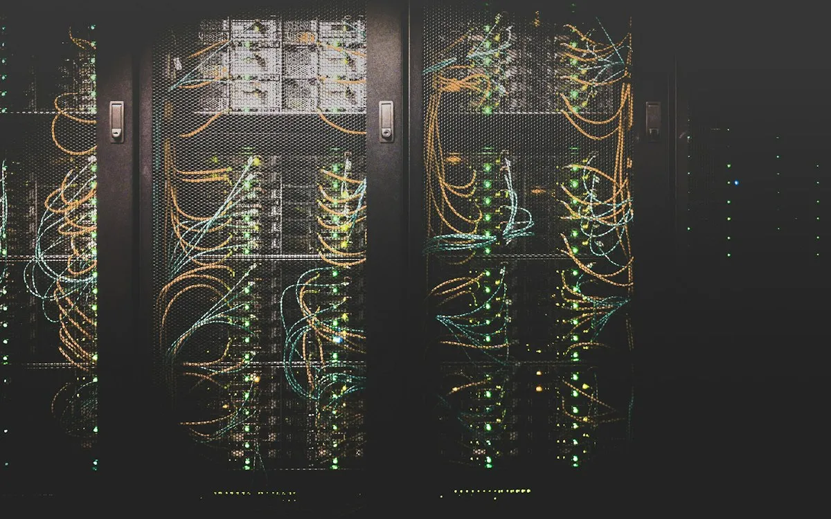 Server racks in a data centre, lit by green status lights.