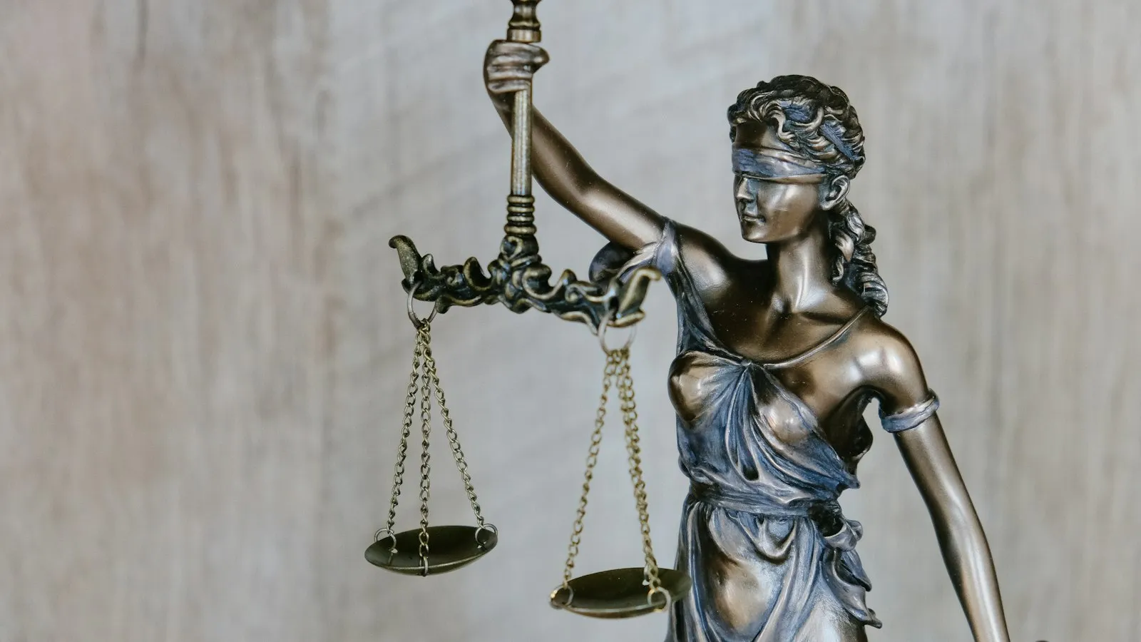 A bronze statue of Lady Justice, blindfolded and holding scales.